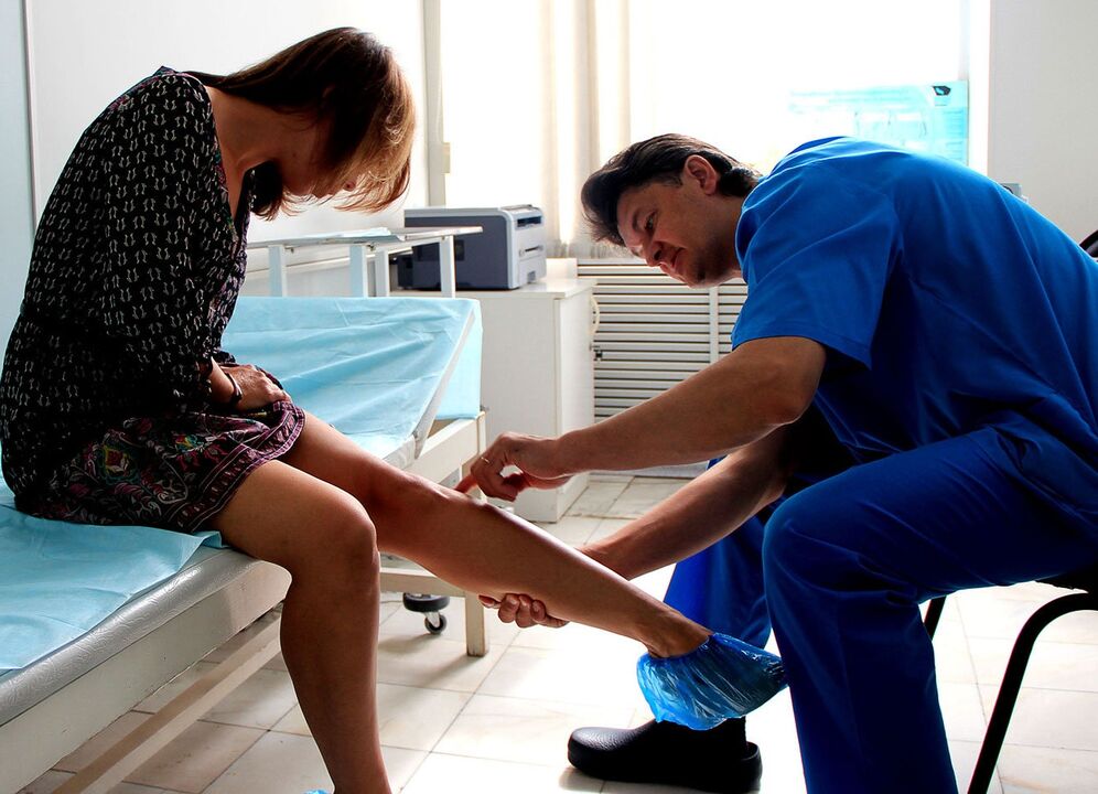 le médecin examine la jambe avec des varices